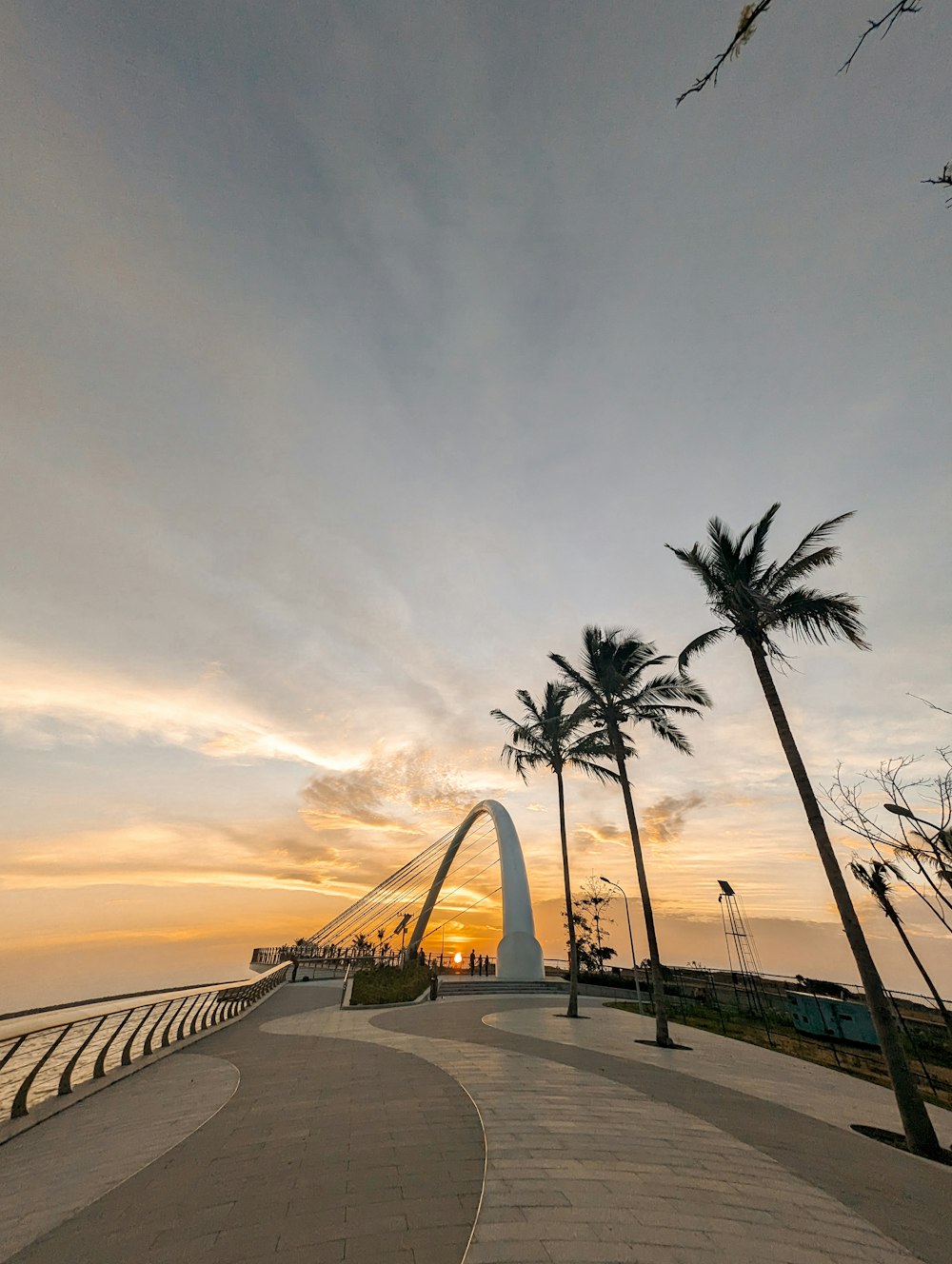 the sun is setting over the ocean and palm trees