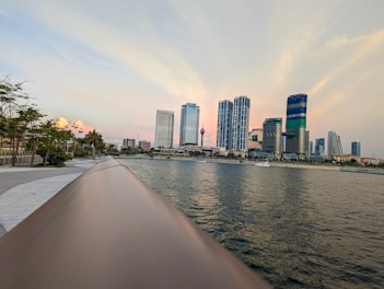 a boat traveling down a river next to tall buildings