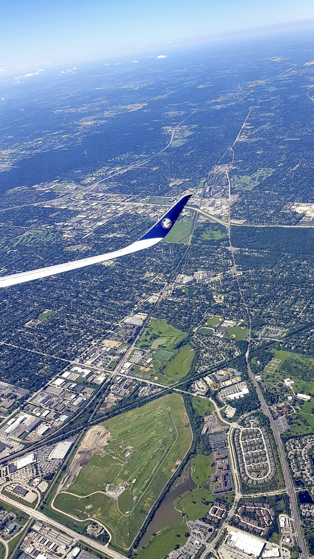 uma vista aérea de uma cidade com um avião no céu