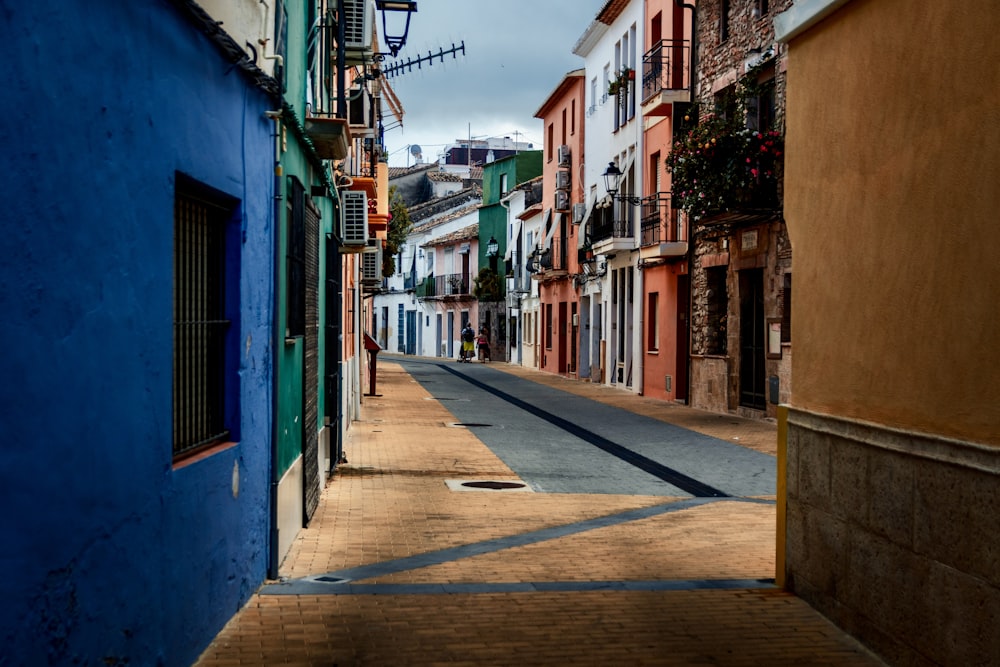 a narrow city street with a blue building