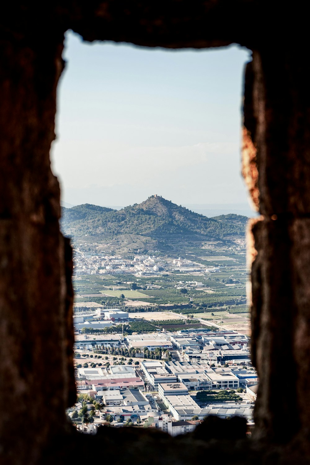 a view of a city through a hole in a wall