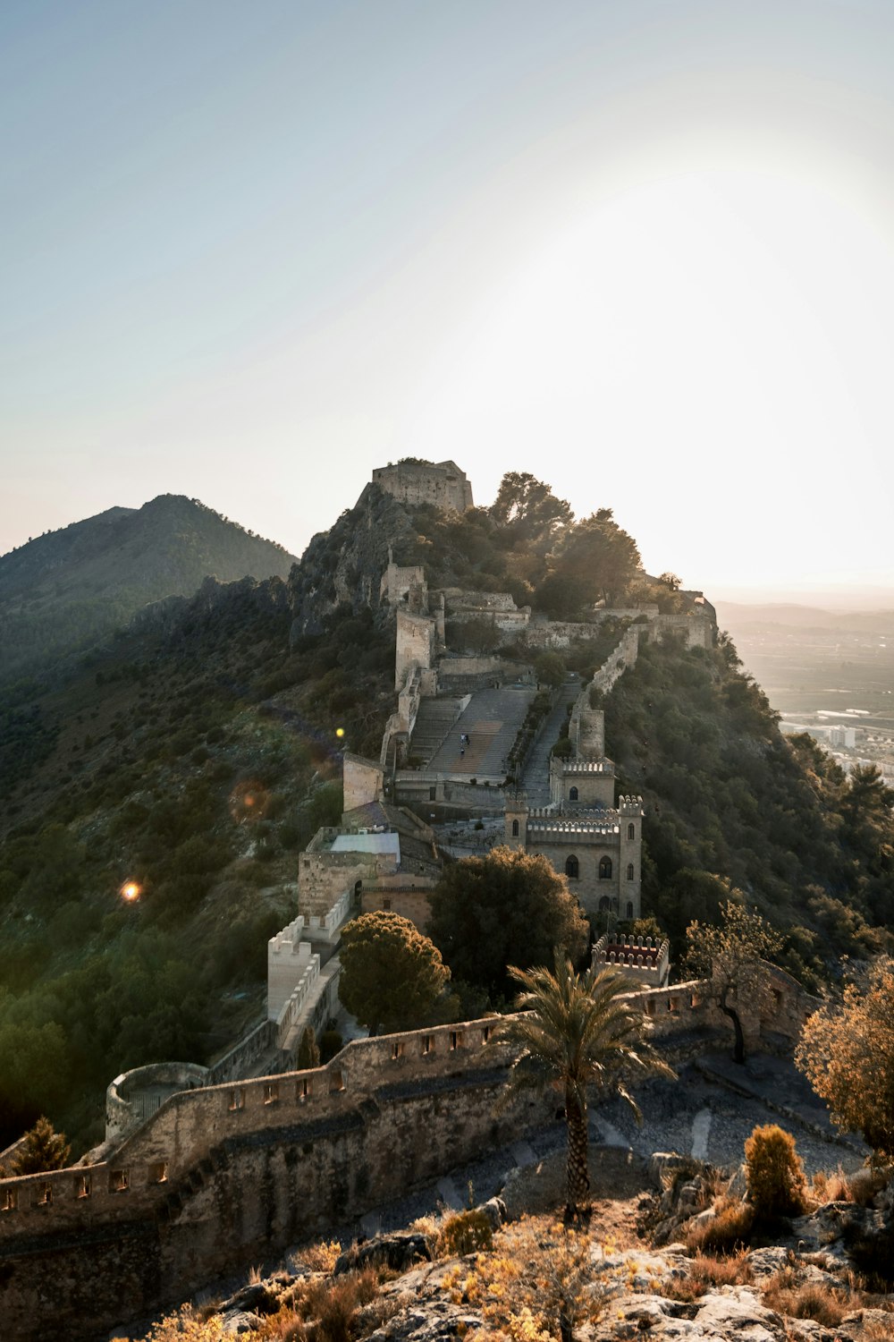 a castle on top of a mountain with a sunset in the background