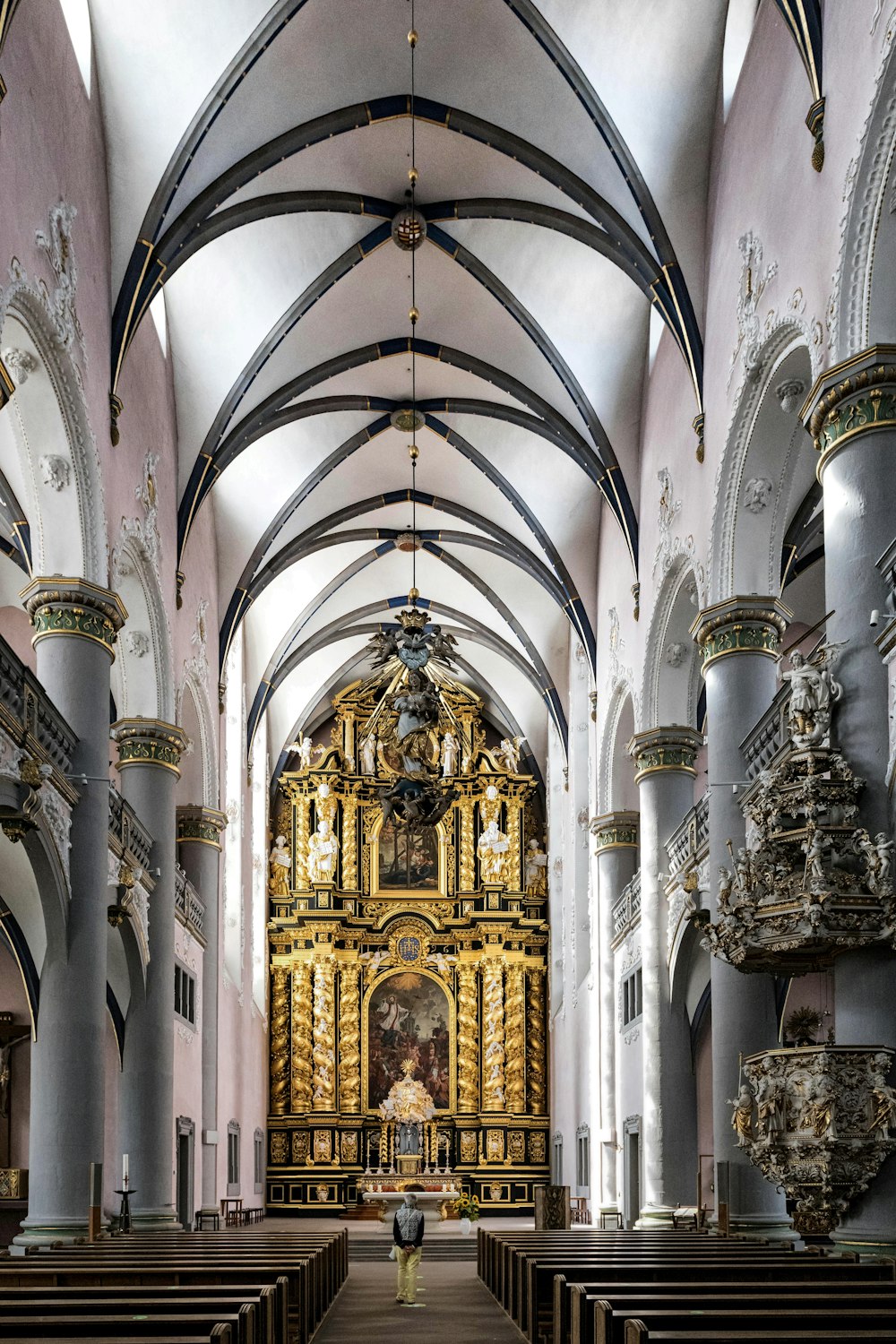 eine Kirche mit Kirchenbänken und einem goldenen Altar