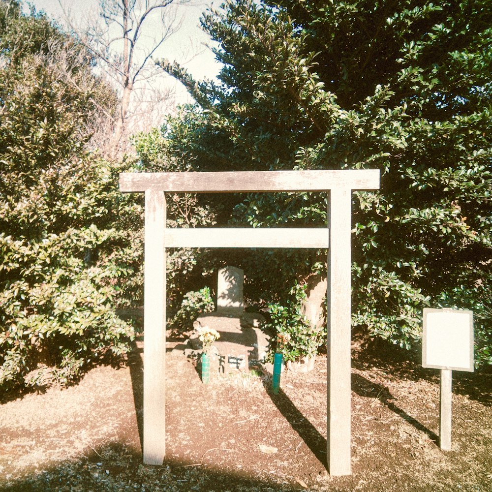 a wooden arch in the middle of a garden