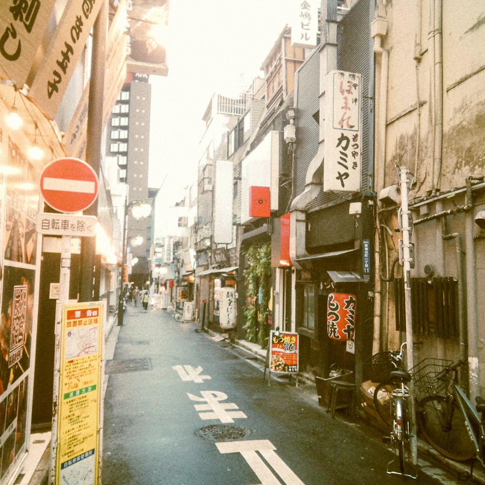 a narrow city street lined with buildings and signs