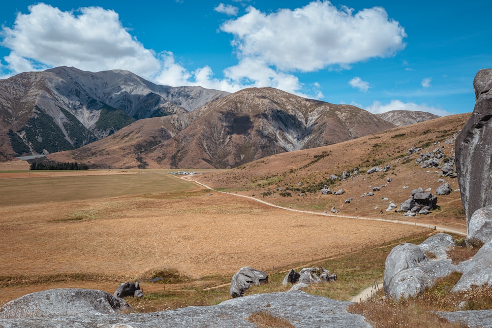 a scenic view of mountains and a dirt road