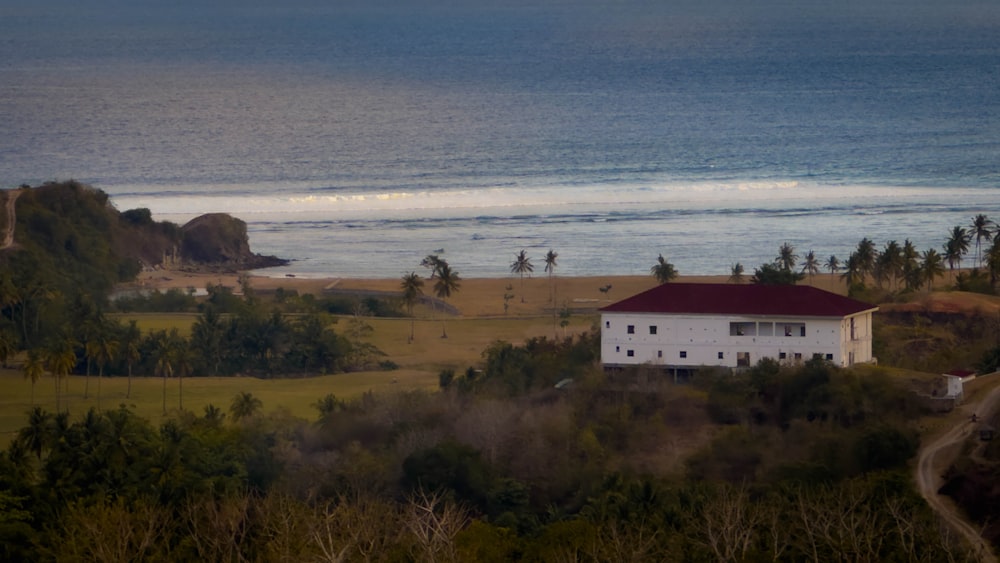 a white house sitting on top of a lush green hillside