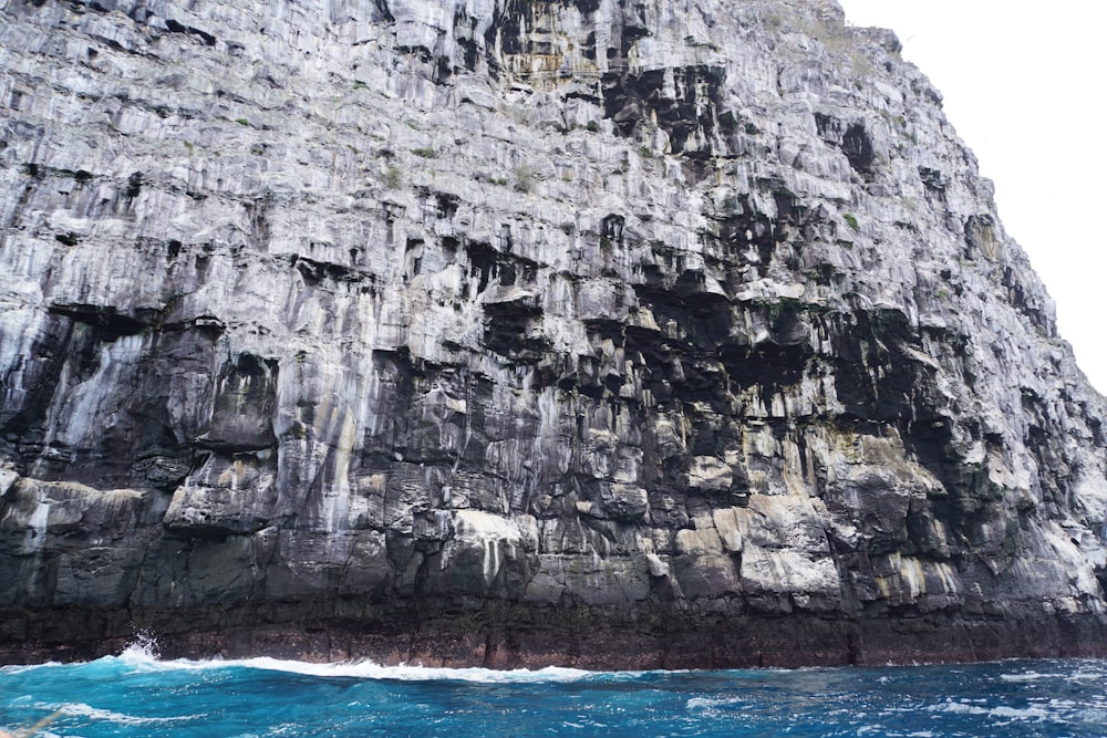 a large rock formation with a boat in front of it