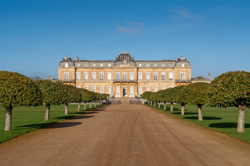 a large building with a dirt road in front of it