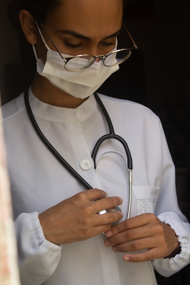 a woman wearing a medical mask and holding a stethoscope