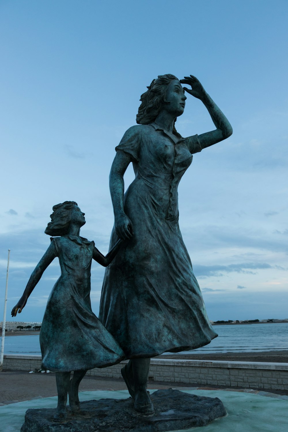 a statue of a woman holding the hand of a young girl