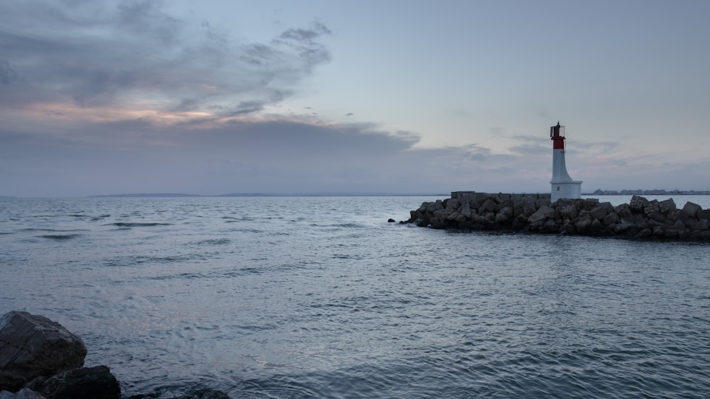 a light house sitting on top of a rock pier