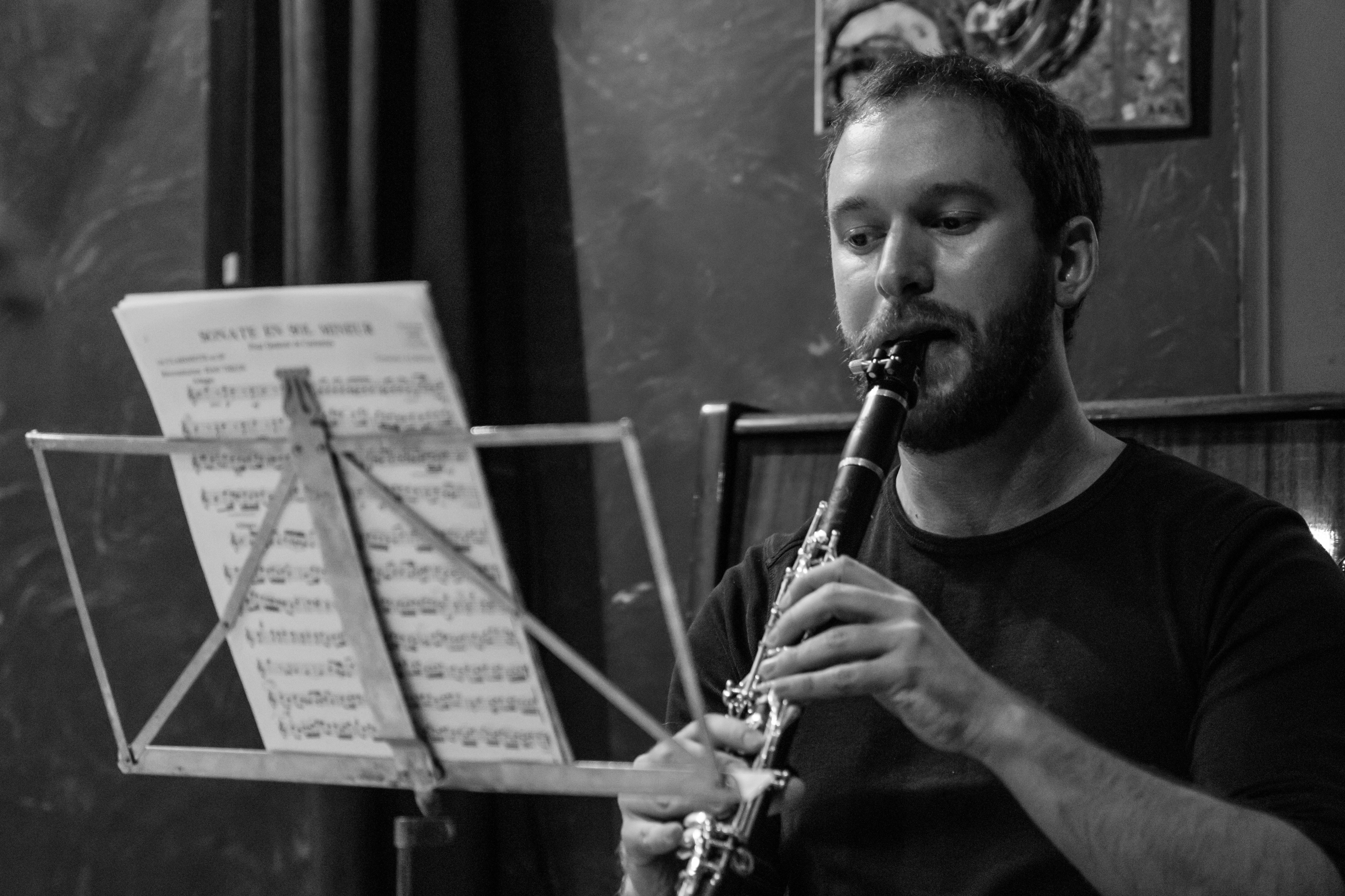 a man playing a flute in front of music sheets