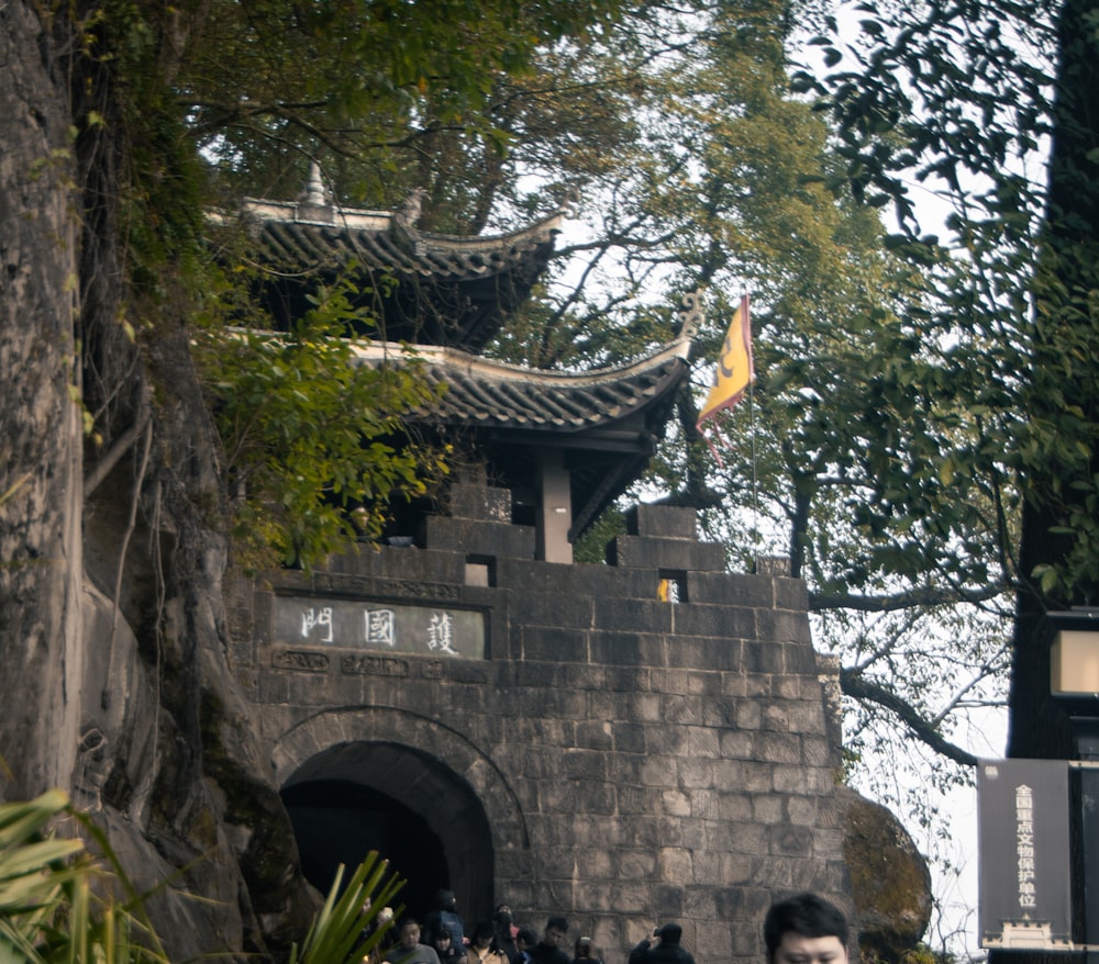 a man standing in front of a stone wall