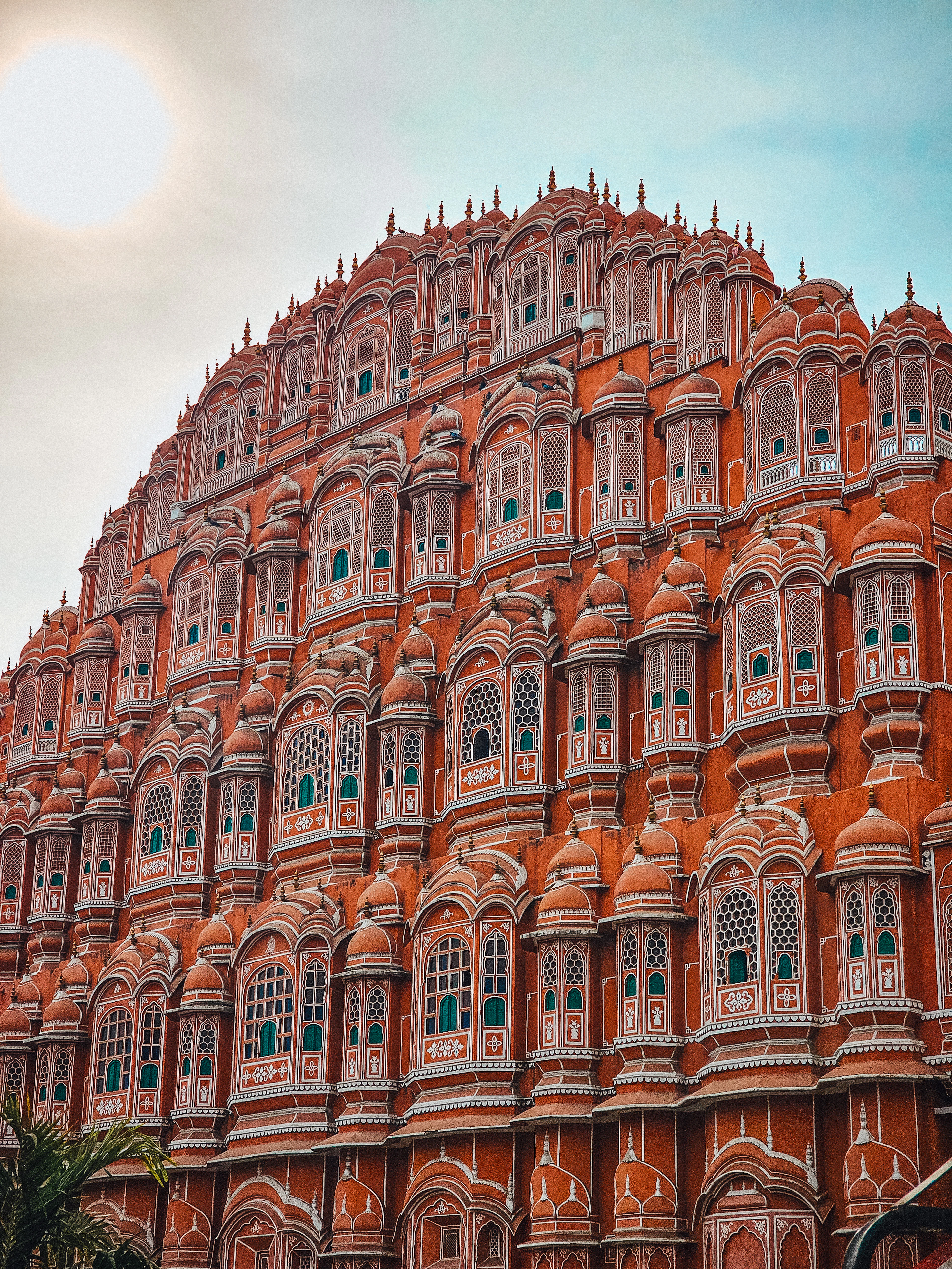 The honeycomb pink sandstone facade of the Hawa Mahal in Jaipur, tier upon tier of small latticed windows