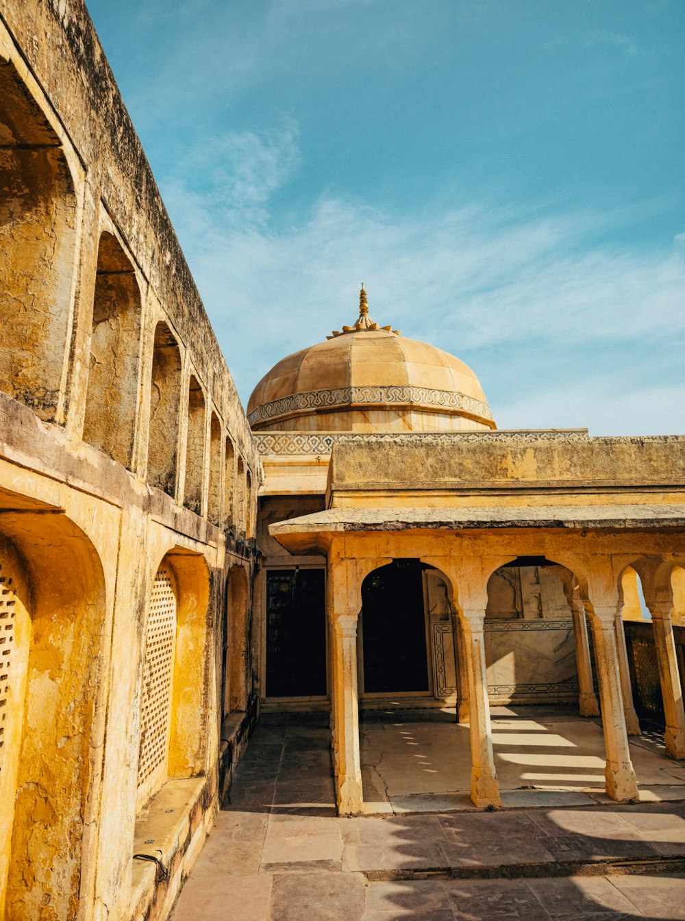 a yellow building with a dome and pillars