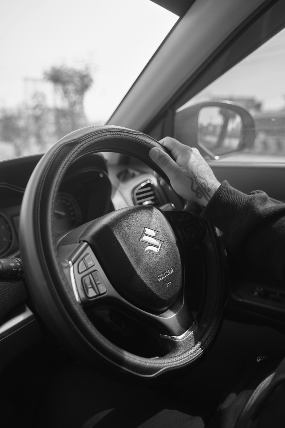 Ein Schwarz-Weiß-Foto einer Person, die ein Auto fährt