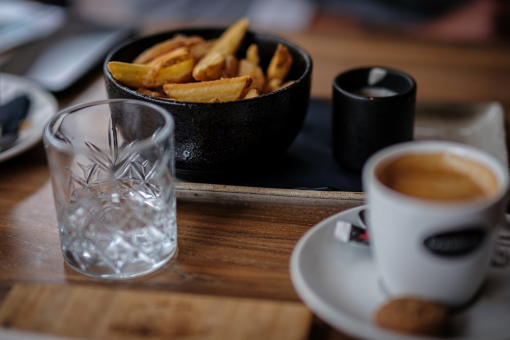 una bandeja de patatas fritas y una taza de café sobre una mesa