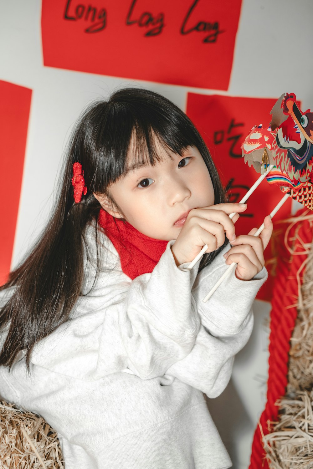 a young girl holding a chinese dragon on a stick