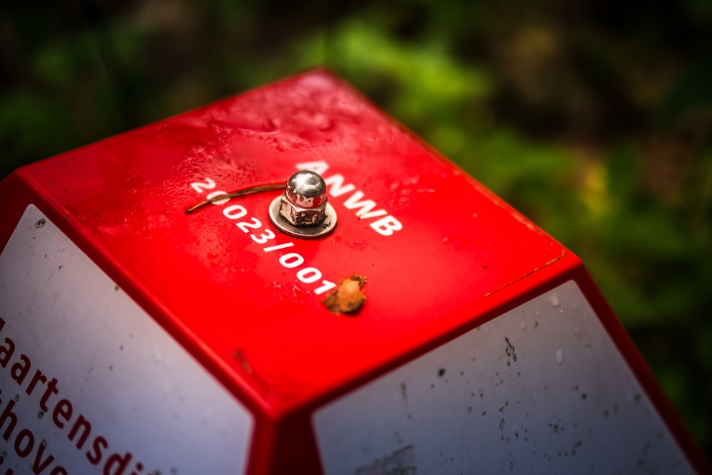 Eine Nahaufnahme eines roten Stoppschilds mit einem Knopf darauf