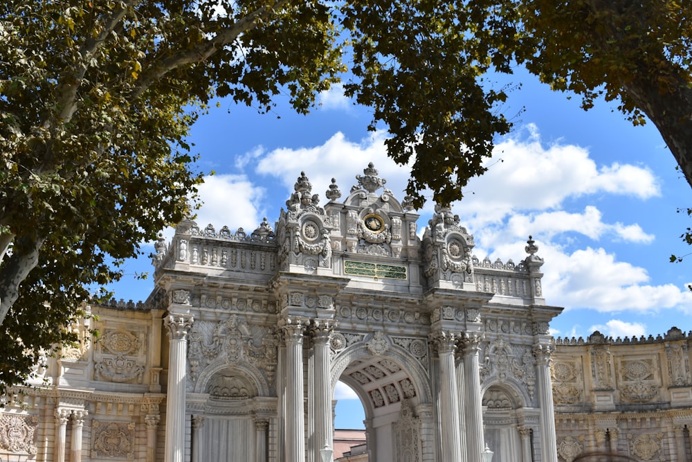 a large white arch with a clock on top of it