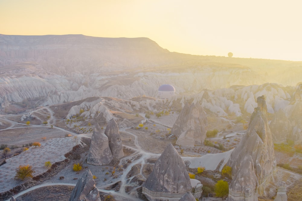 a hot air balloon flying over a rocky landscape