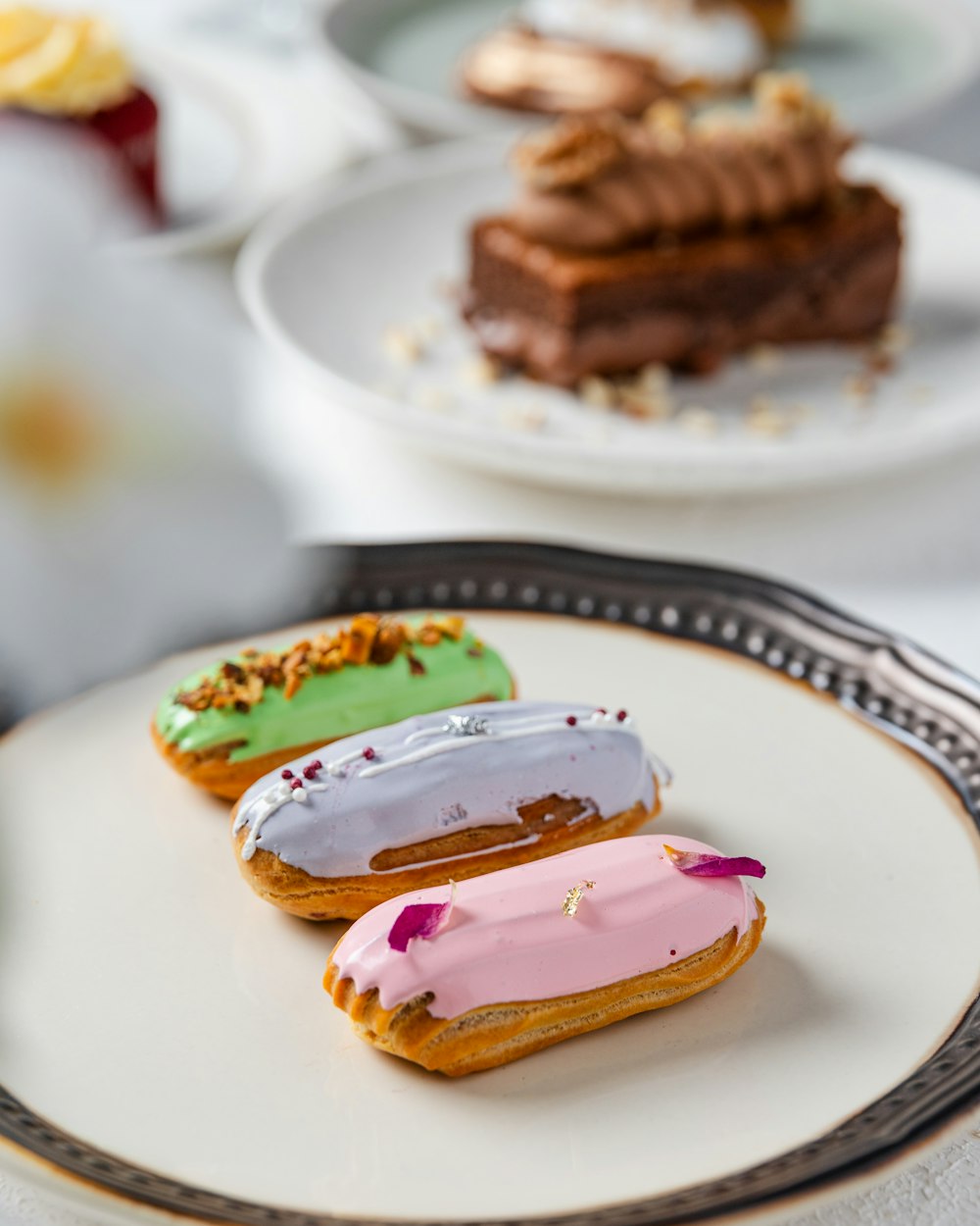 a white plate topped with three donuts covered in frosting