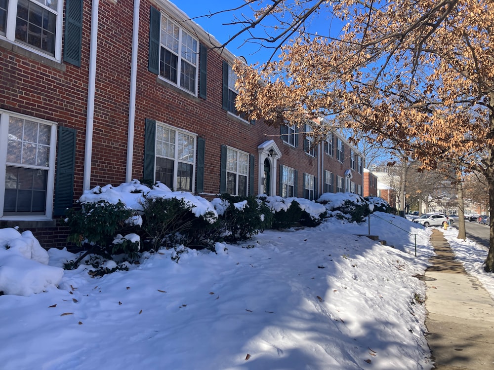 a snow covered sidewalk next to a brick building