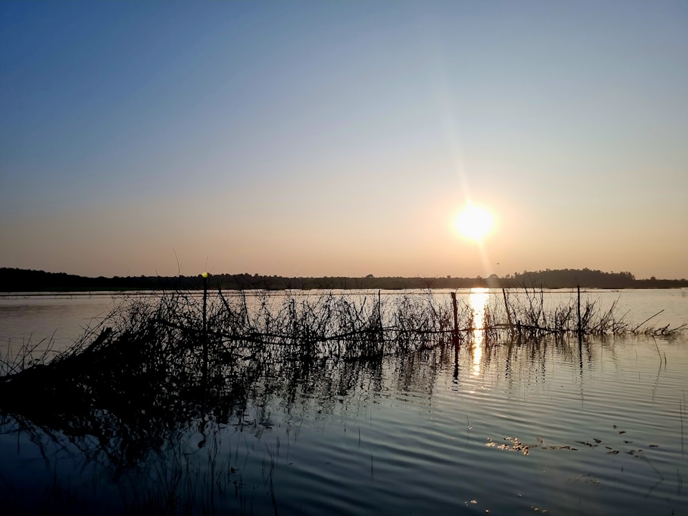 the sun is setting over a body of water