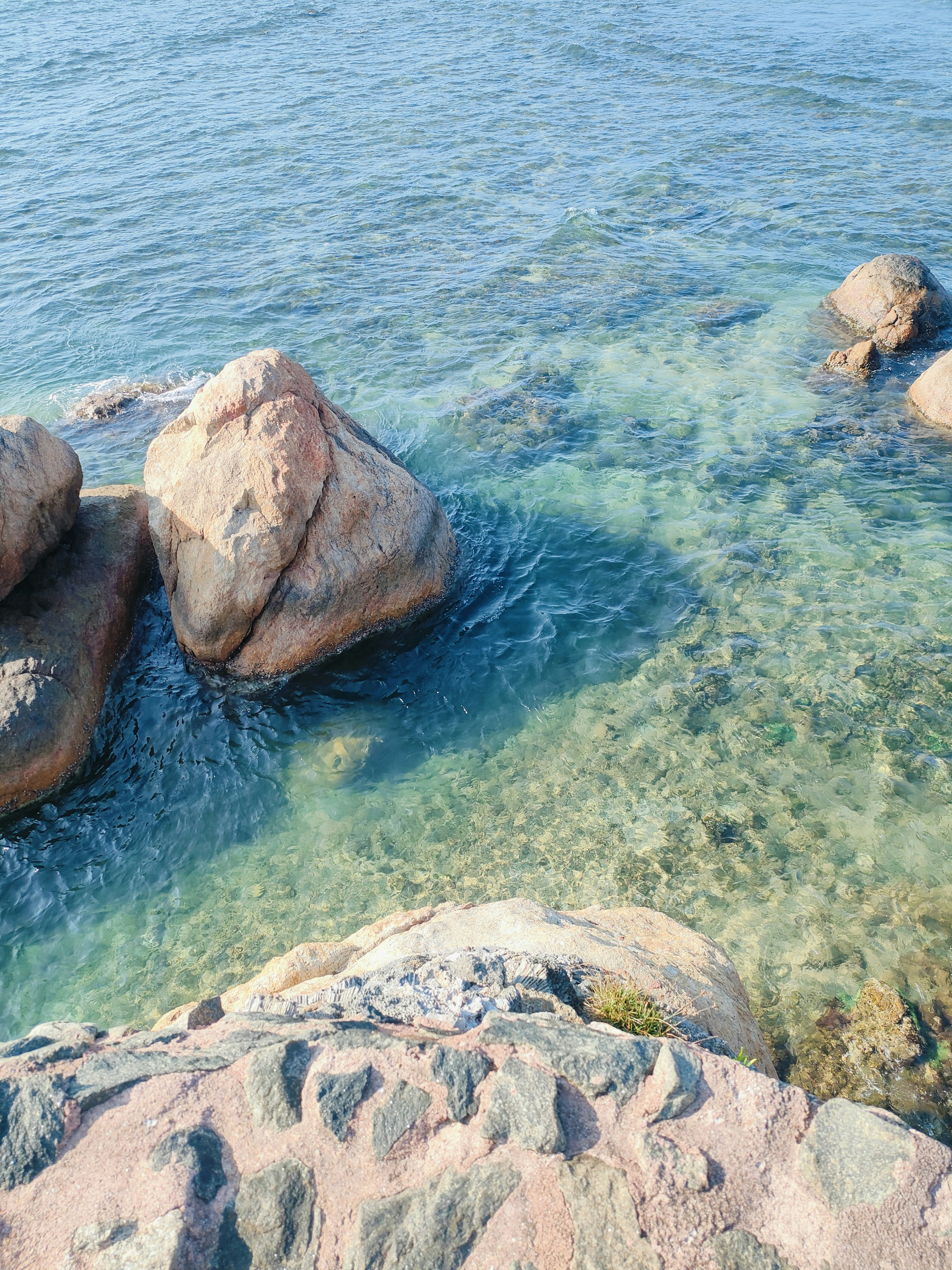 A couple of rocks sitting on top of a body of water photo – Free ...