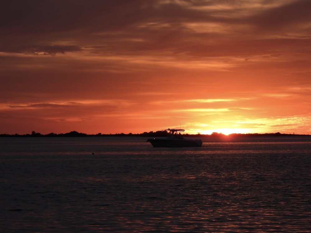 a boat in a body of water at sunset