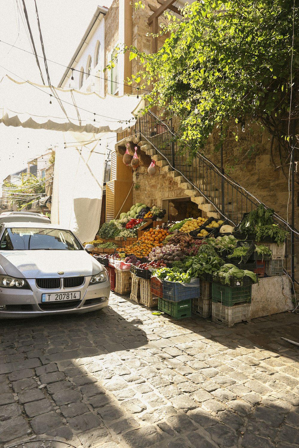 a car parked in front of a fruit and vegetable stand