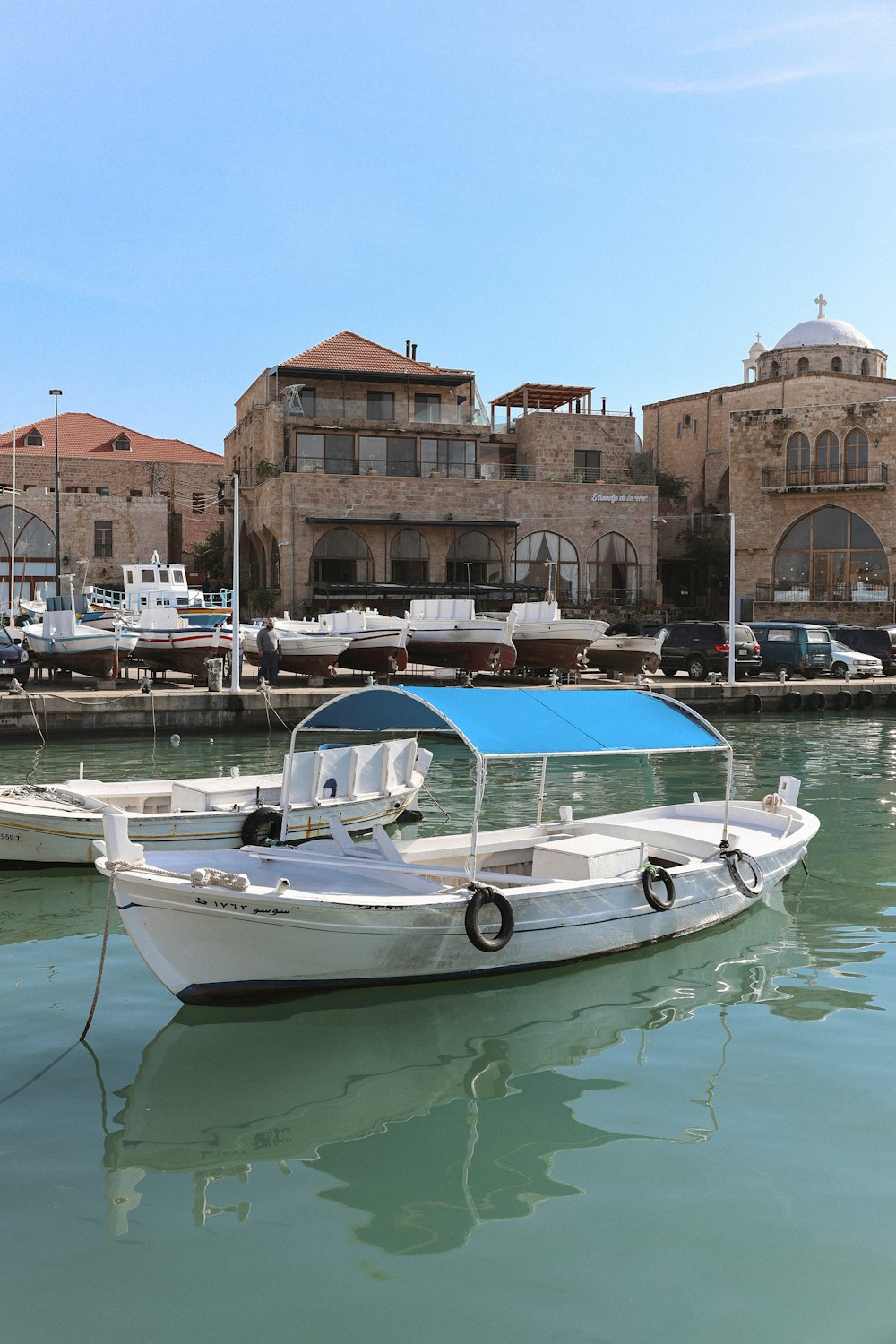 a small white boat in the water next to a building