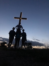 a group of people standing in front of a cross