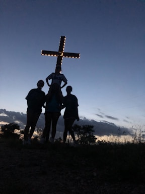 a group of people standing in front of a cross