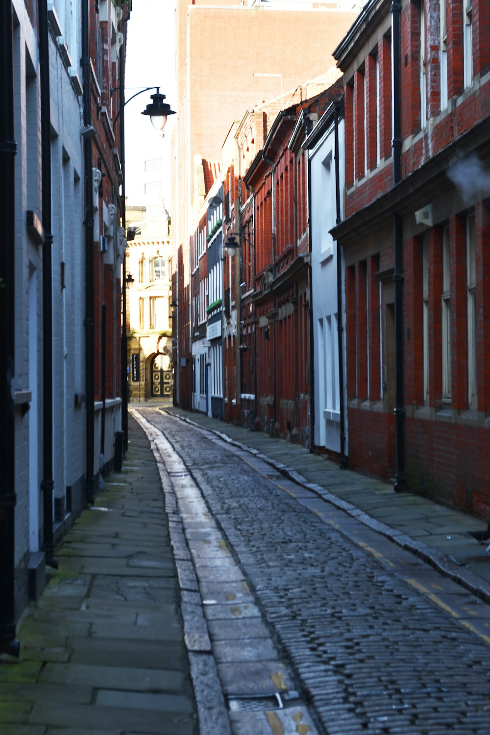 a cobblestone street lined with red brick buildings