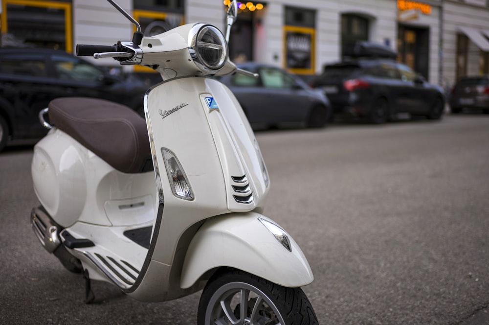 a white scooter parked on the side of the road