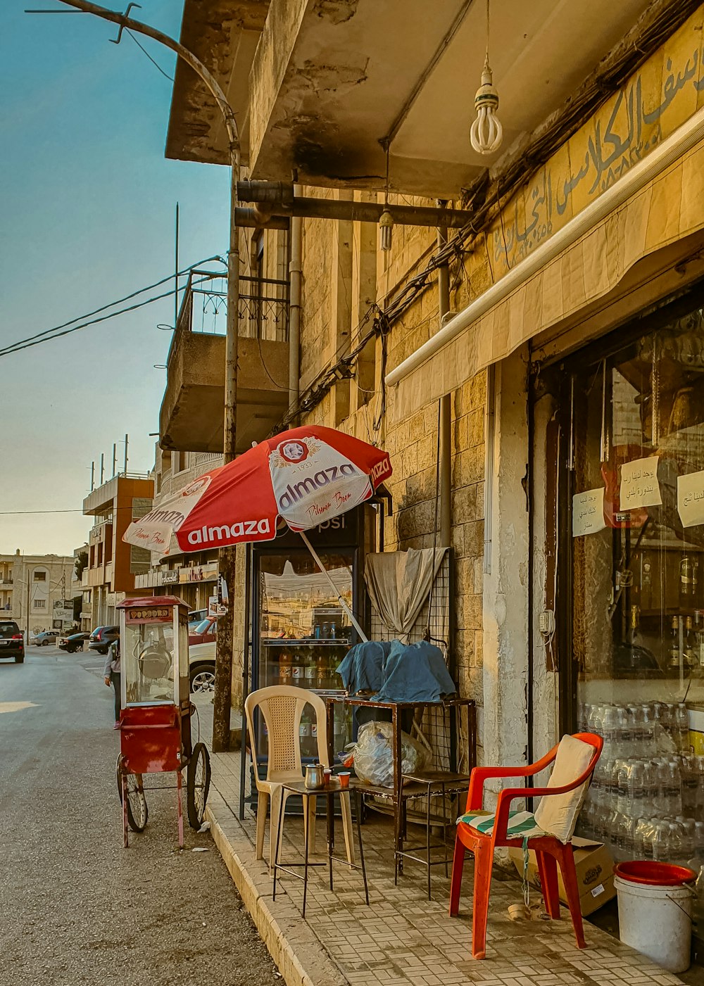 a store front with chairs and umbrellas outside of it