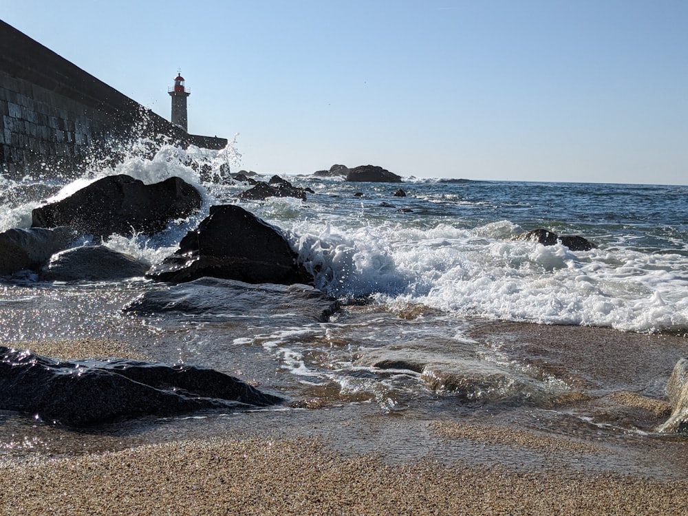 a lighthouse on a rocky shore near the ocean