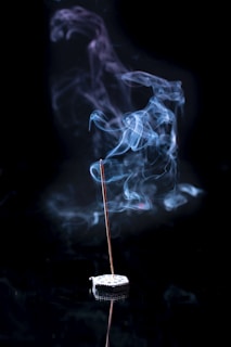 a incense stick with smoke coming out of it