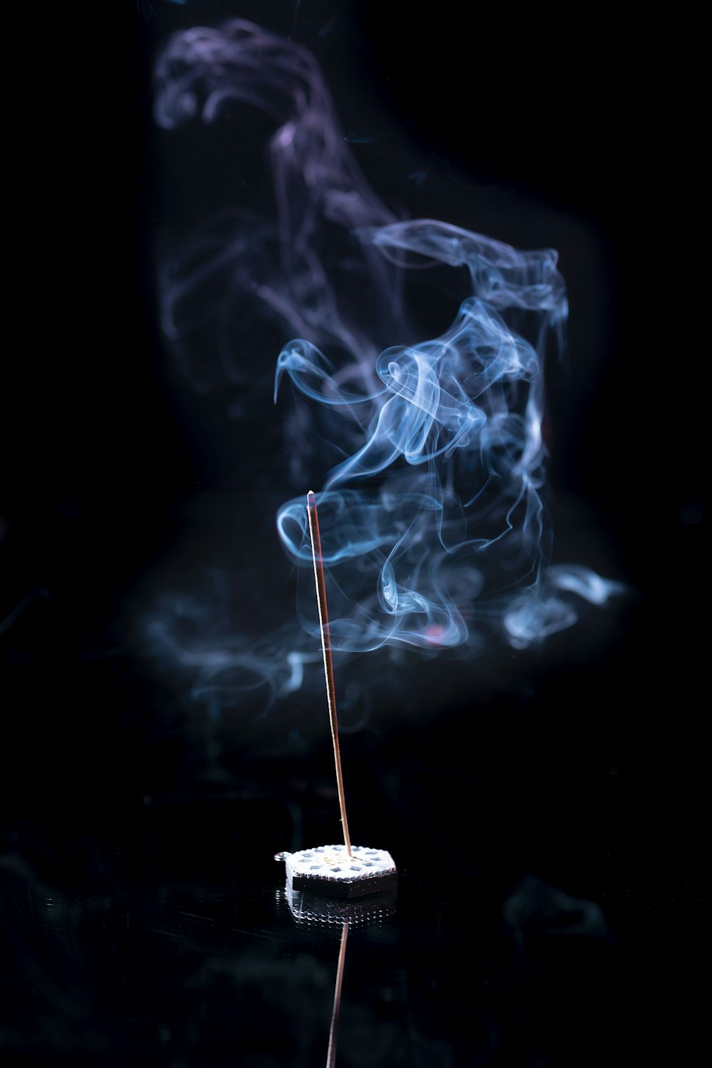 a incense stick with smoke coming out of it
