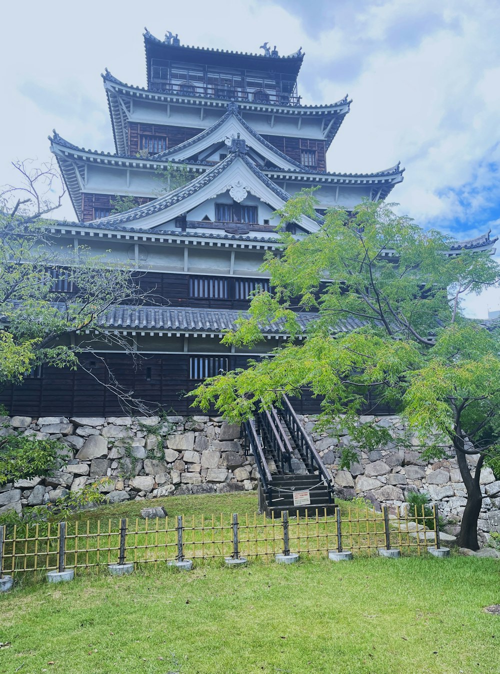 a tall building sitting on top of a lush green field