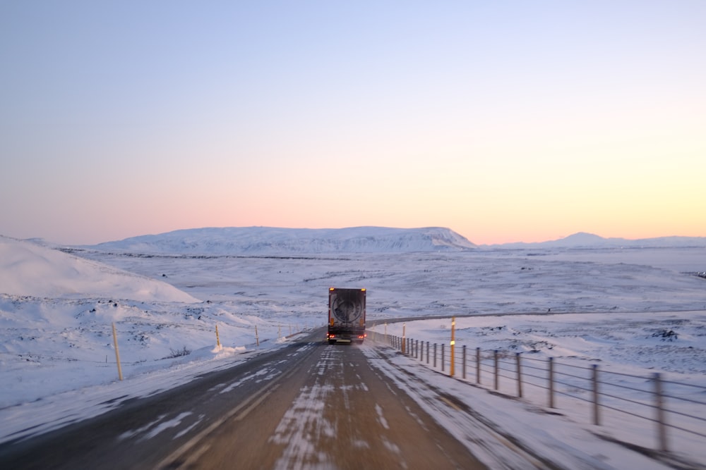a semi truck driving down a snowy road