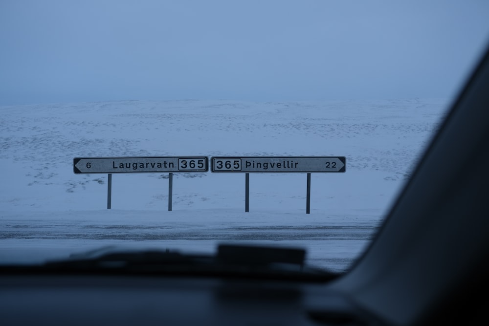a street sign in front of a snowy mountain