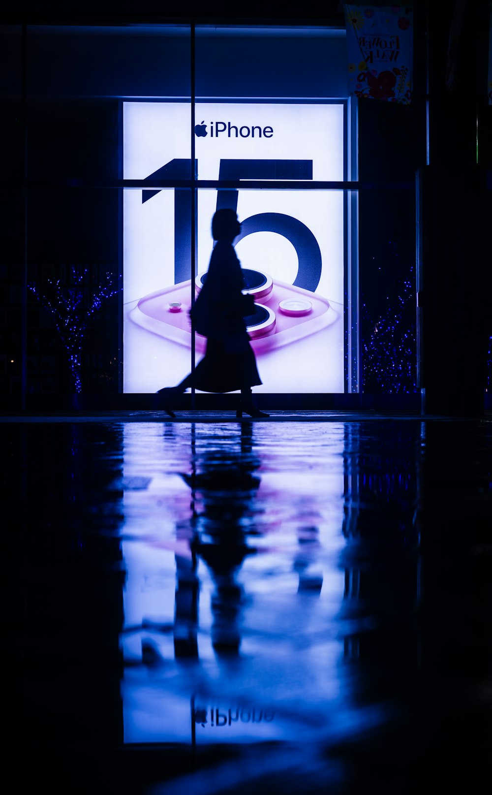 a woman walking past a store front with a sign on it