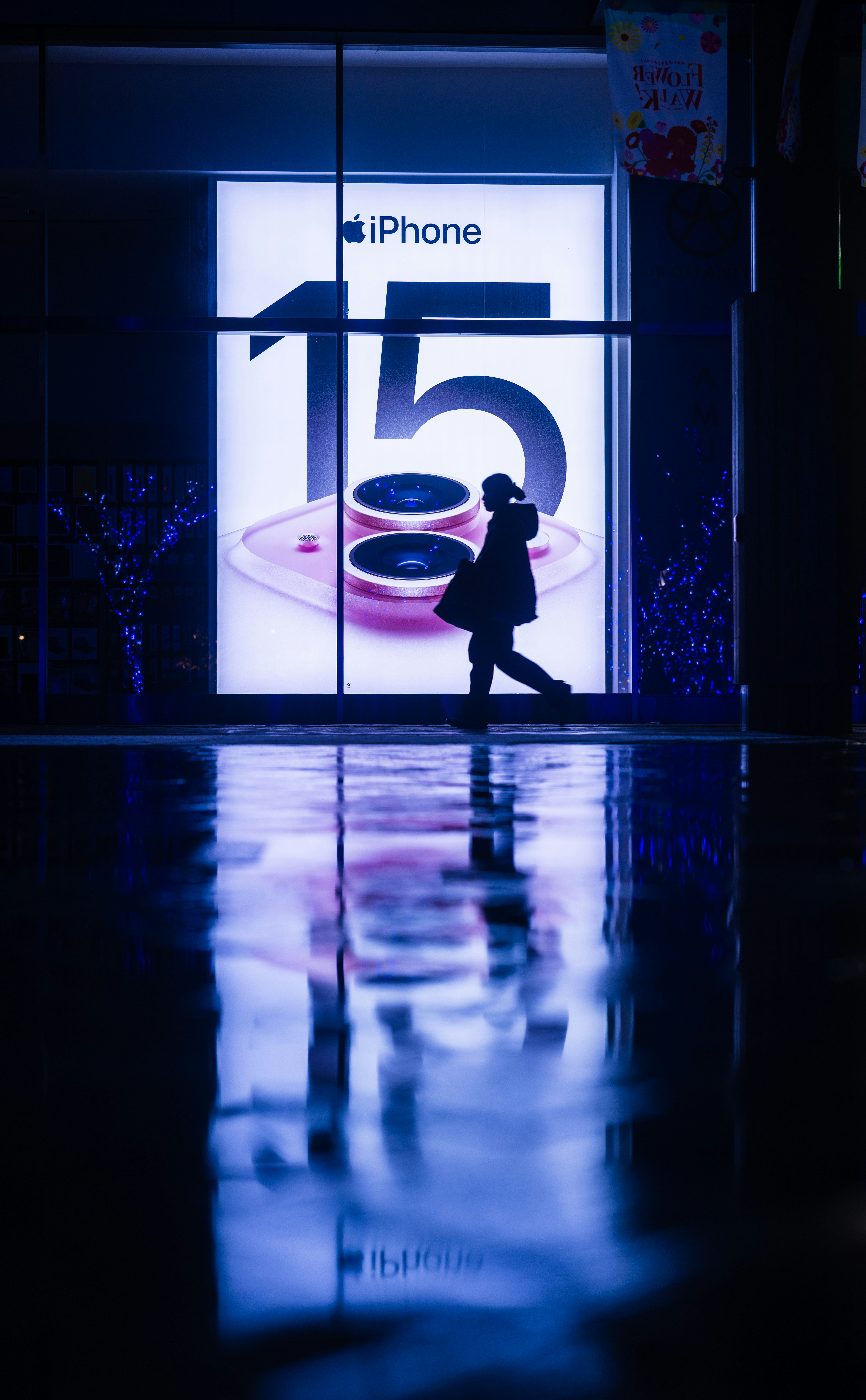 eine Person, die an einer Ladenfront mit blauem Hintergrund vorbeigeht