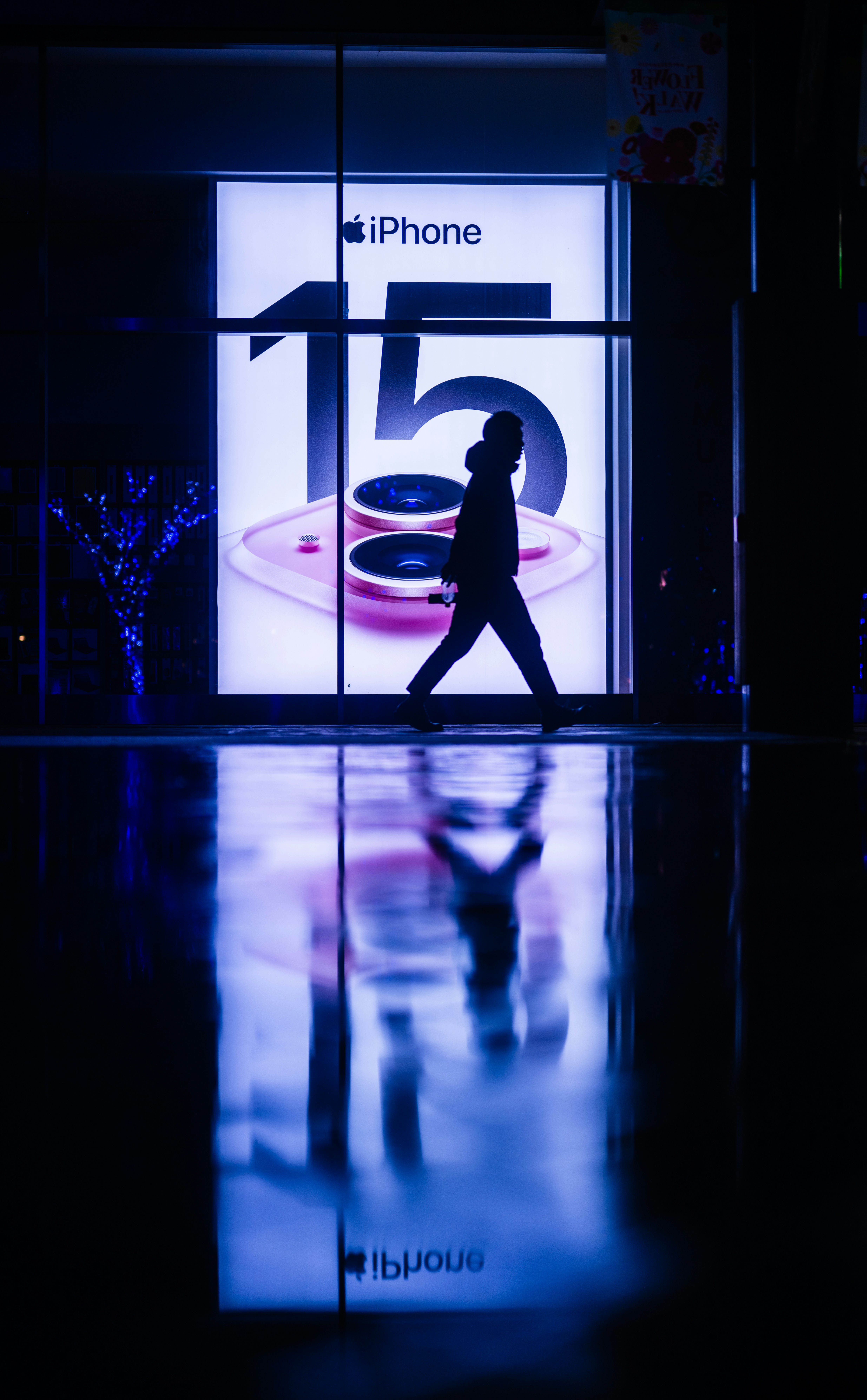 eine Person, die an einer Ladenfront mit einem großen Fenster vorbeigeht