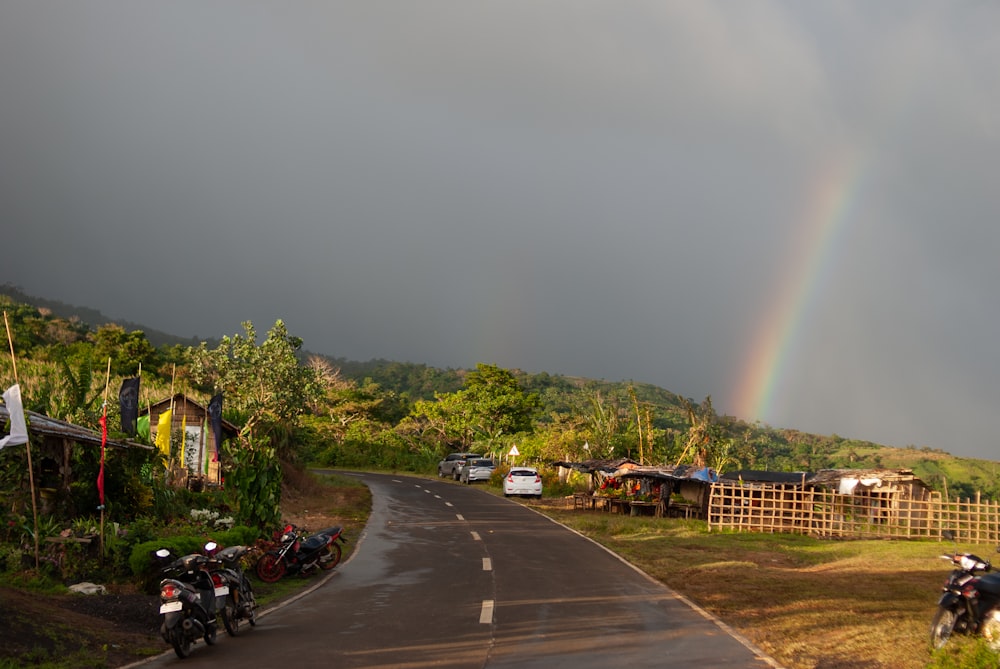 un arcobaleno nel cielo sopra una strada rurale