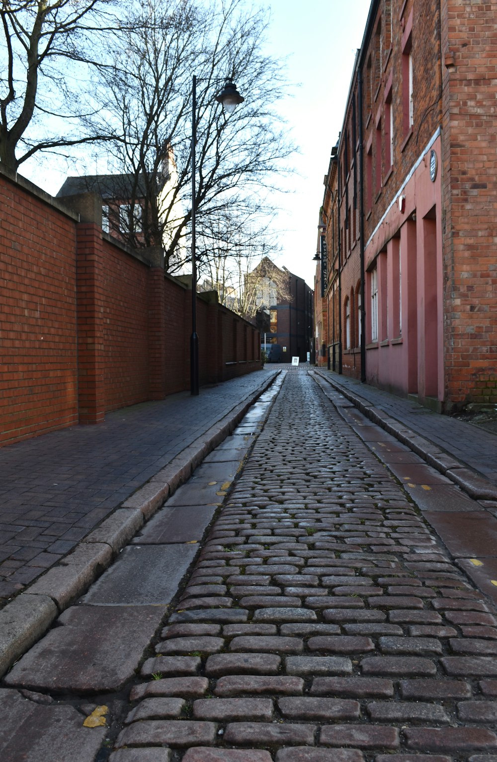 a cobblestone street lined with brick buildings