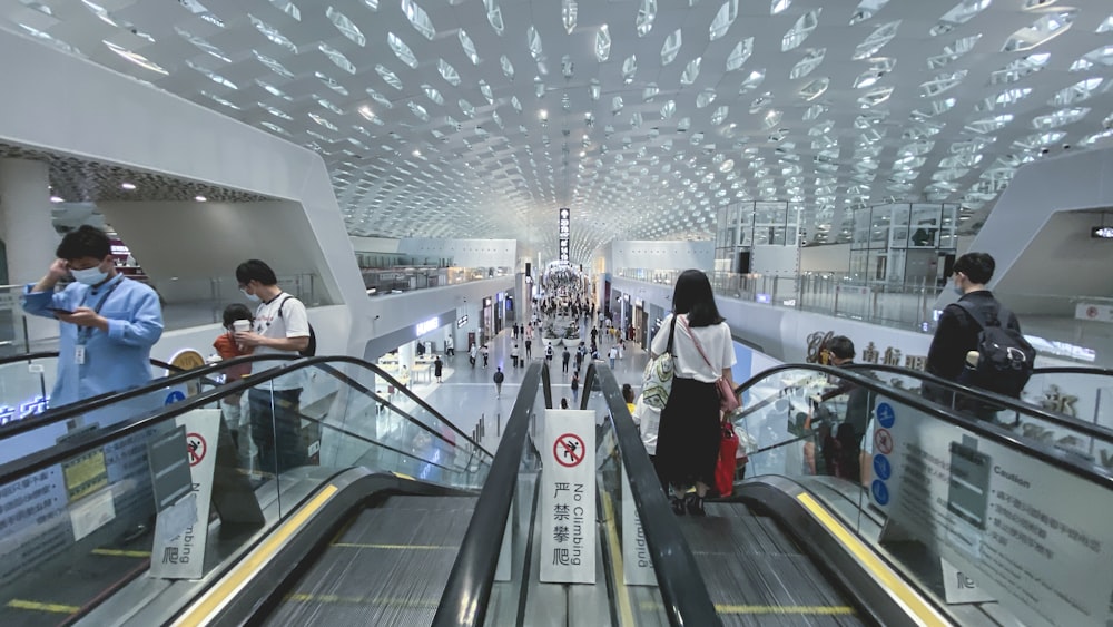 a group of people riding down an escalator